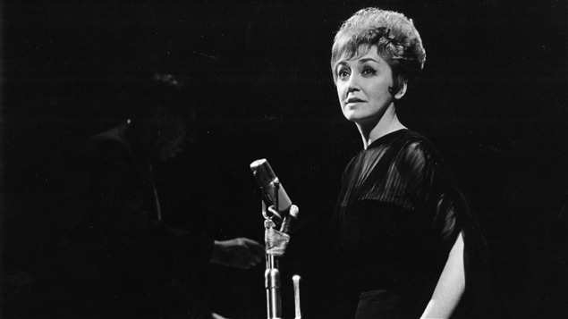 En 1963 sur la scène de la Comédie-Canadienne, à Montréal, la chanteuse Lucille Dumont, représentant le Canada, interprète une chanson.