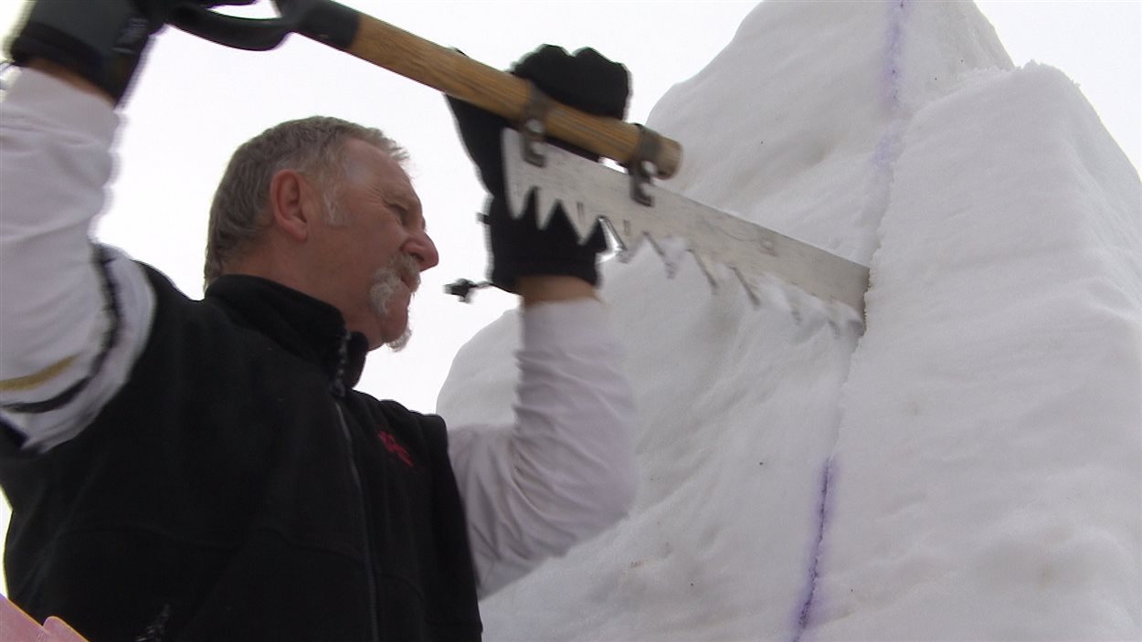 sculpteur de neige insère une scie 