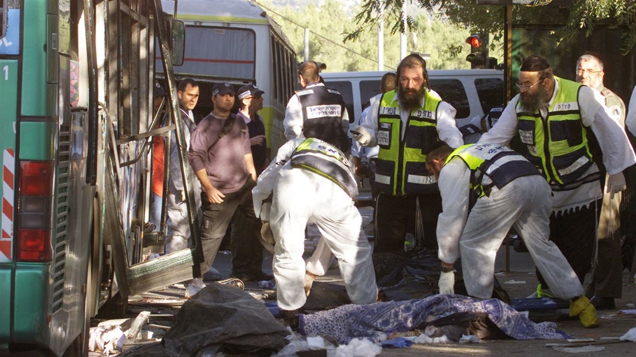 Des sauveteurs israéliens sont sur la scène d'une attaque-suicide à la bombe perpétrée par un Palestinien en novembre 2002.