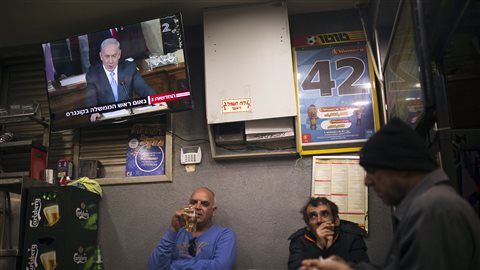 Des citoyens de la ville d'Ashkelon, en Israël, regardent le discours de leur premier ministre.