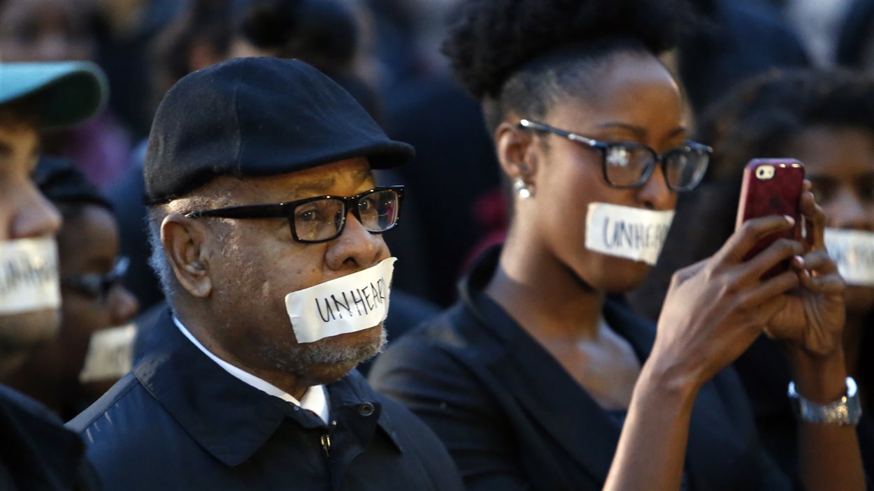 Des dizaines de personnes, dont le professeur Georges Henderson, ont participé à une manifestation pour dénoncer la vidéo raciste lundi matin.