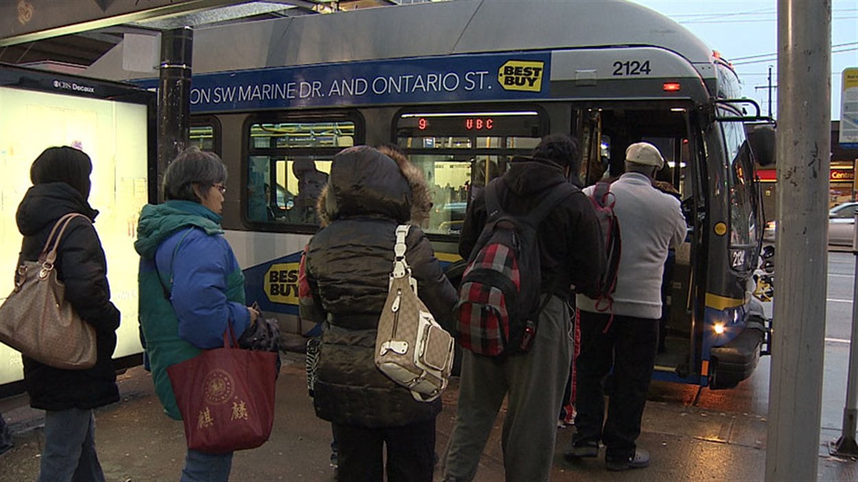 Des passagers attendent de monter dans l'autobus à Vancouver