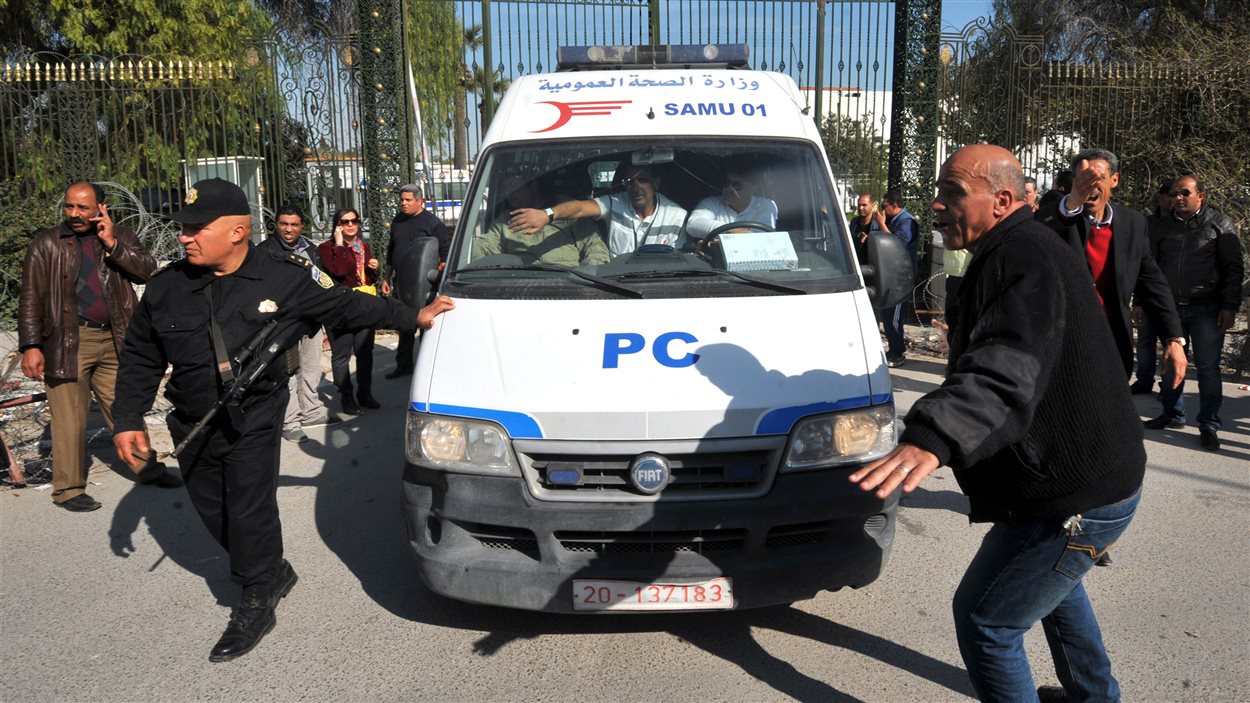 Des membres des forces de l'ordre protègent une ambulance sur les lieux de l'attentat.