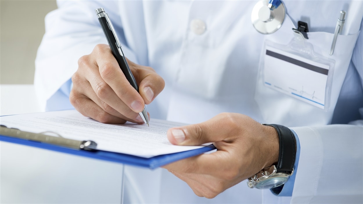 Un médecin remplit une fiche médicale.