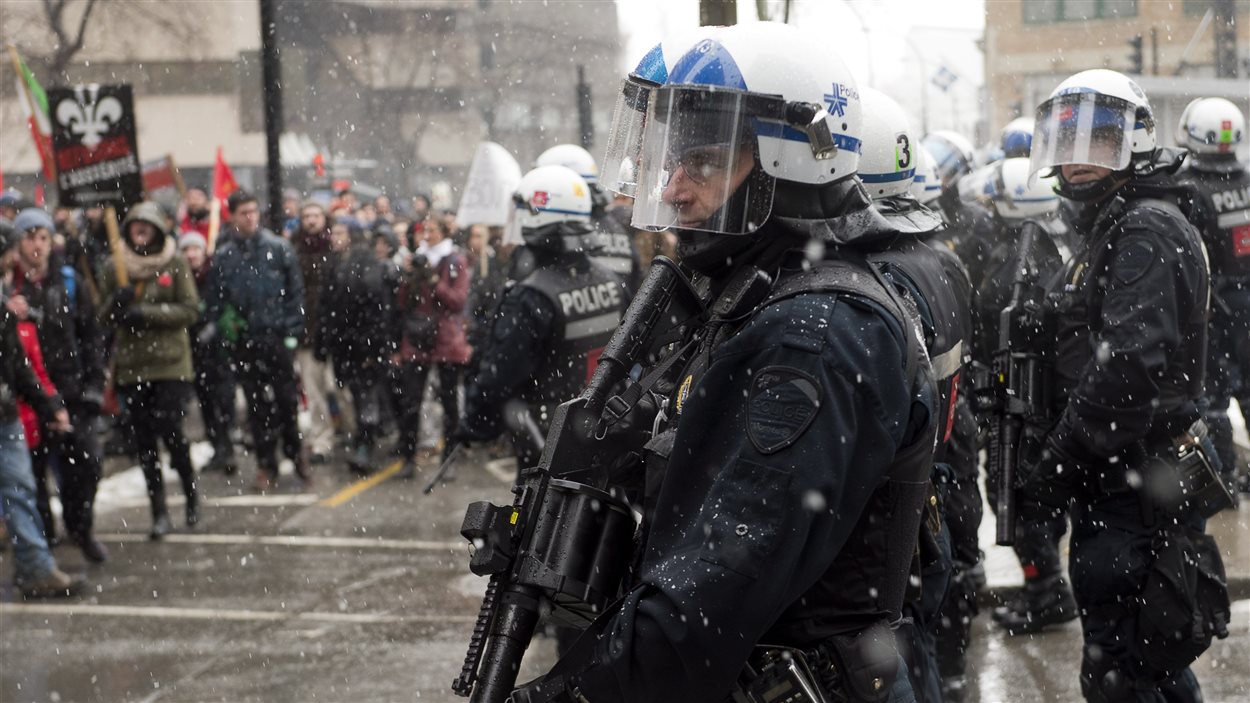 Des policiers surveillent la manifestation contre l'austérité à Montréal.