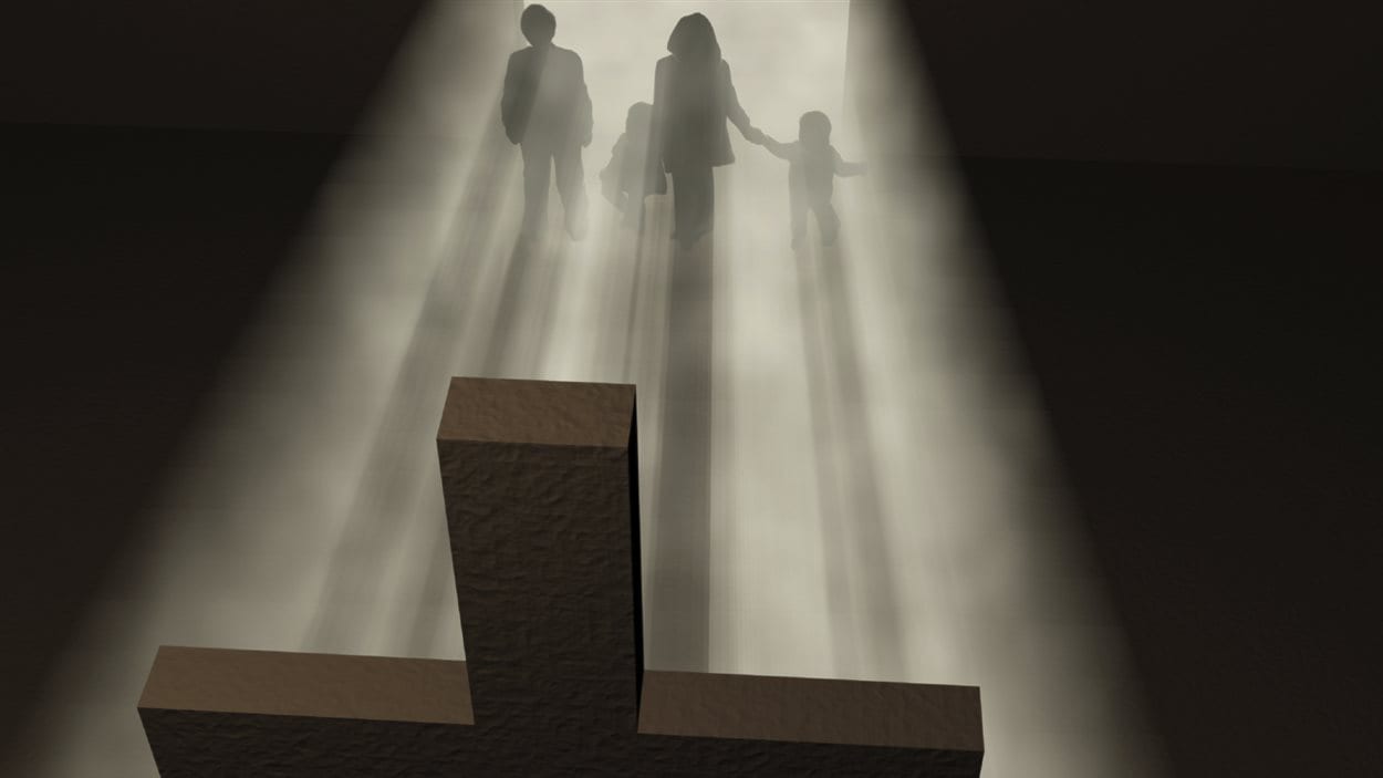 Une famille face à une croix