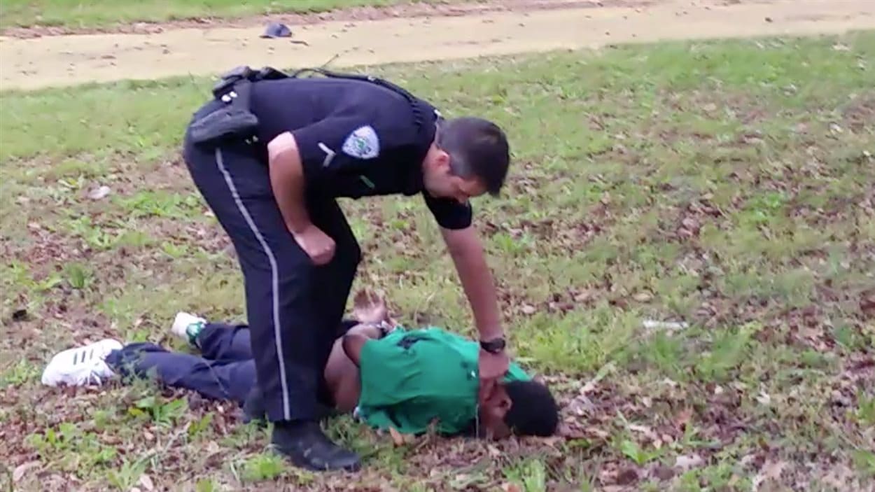 Sur cette image extraite d'une vidéo fournie par l'avocat de la famille Scott, le policier Slager prend le pouls de la victime, qu'il vient d'abattre de huit coups de feu dans le dos.