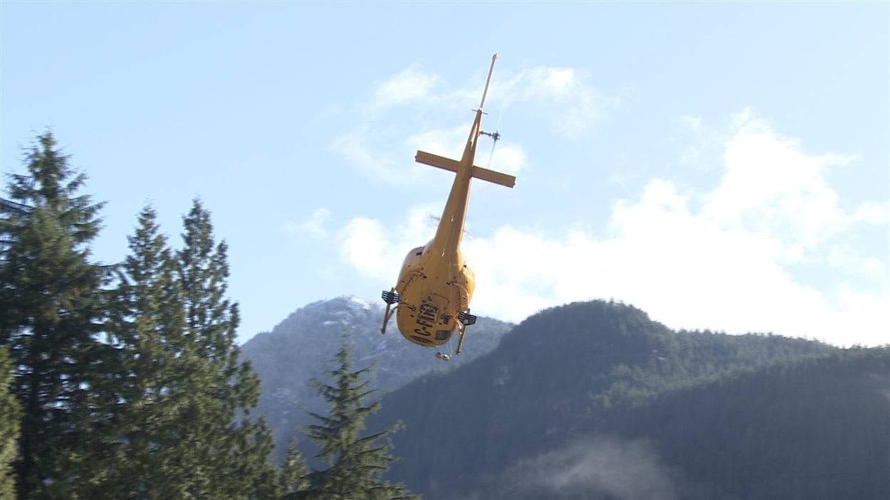 Un hélicoptère s'envole vers les montagnes.