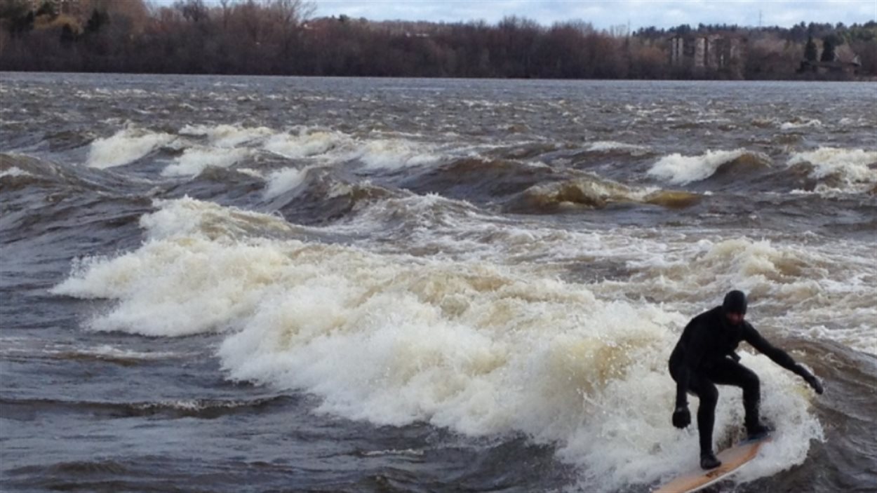 Trevor Cunningham profite d'une grosse vague sur la rivière des Outaouais.