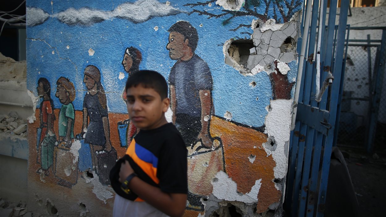 Un jeune palestinien devant une école de l'ONU qui abritait des personnes déplacées durant le conflit à Gaza à l'été 2014