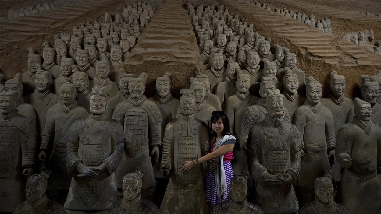 Une jeune femme enlace une copie des statues en terre cuite de l'armée de Qin Shi Huang au musée à Xi'an. (archives)