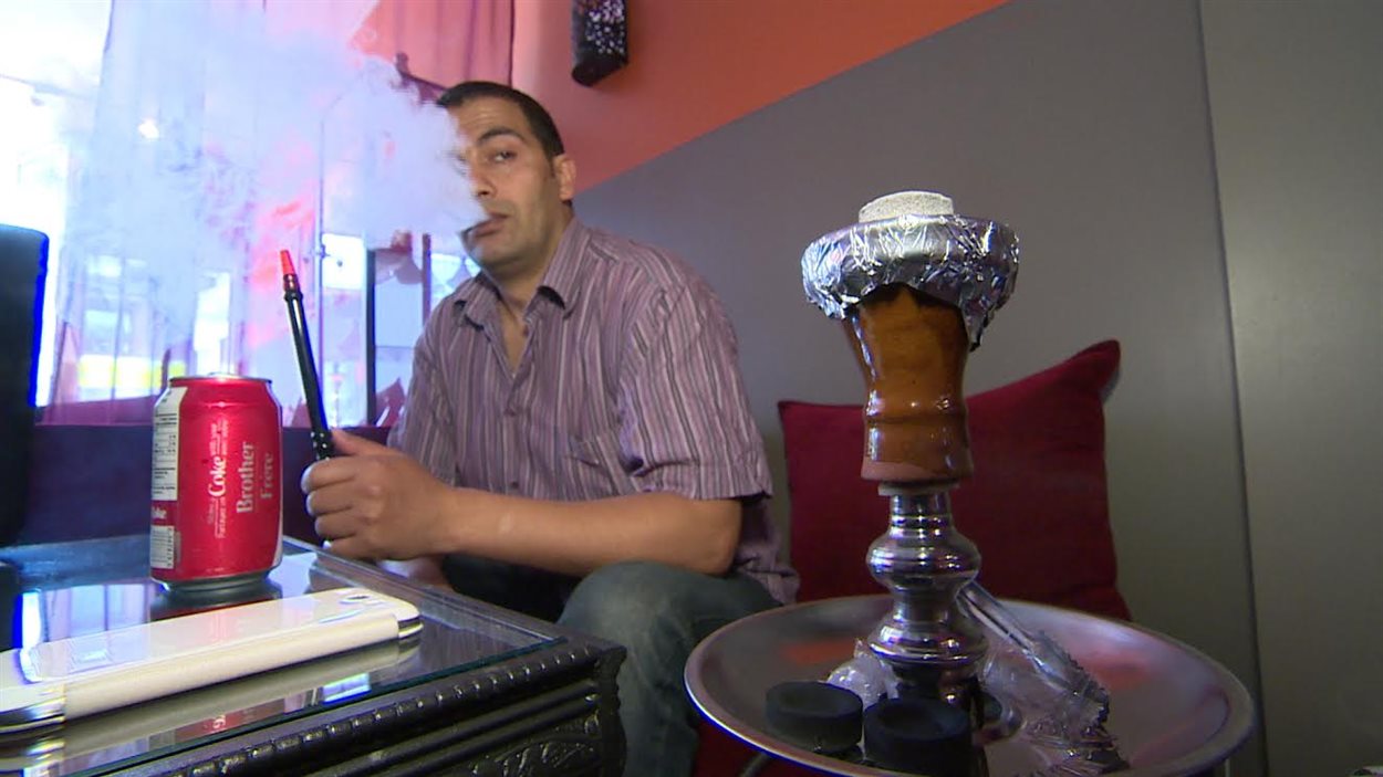 Un Torontois d'origine marocaine fume de la chicha au café Desert Rose dans l'est de la métropole.