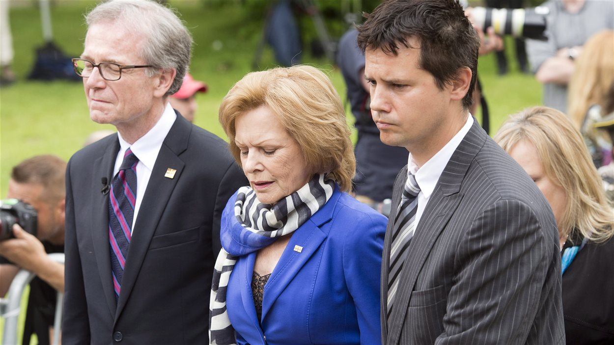 La femme de Jacques Parizeau est escortée par des proches au moment de l'entrée du cercueil dans l'église. 