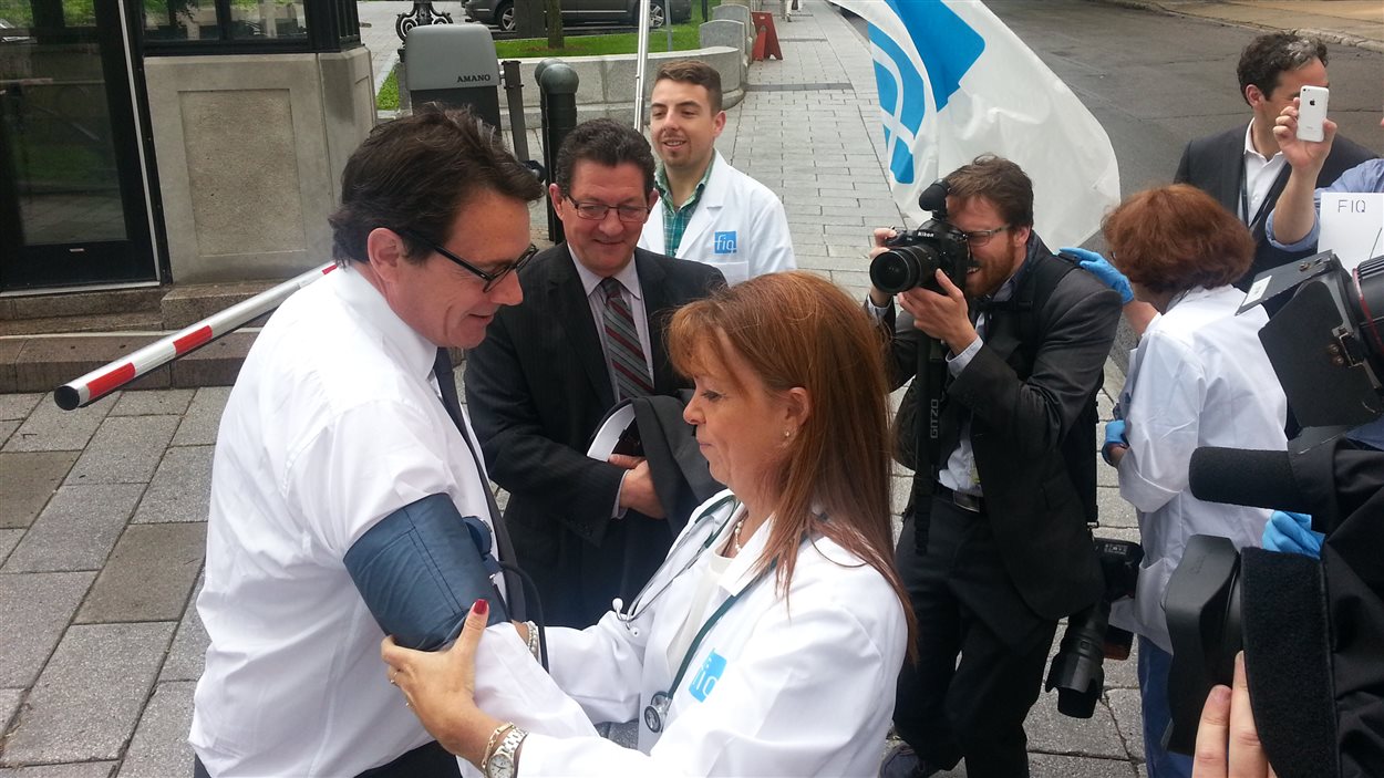 Une infirmière mesure la pression de Pierre Karl Péladeau.