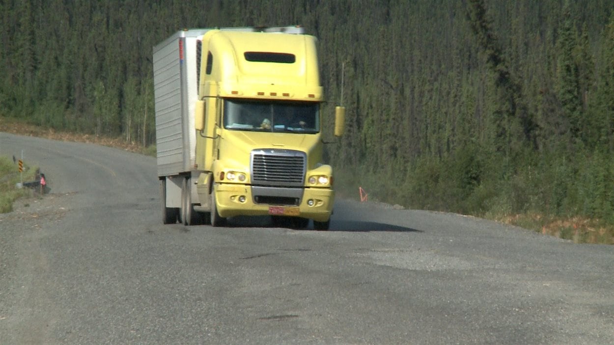 Un camion de transport tente d'éviter les trous sur la chaussée