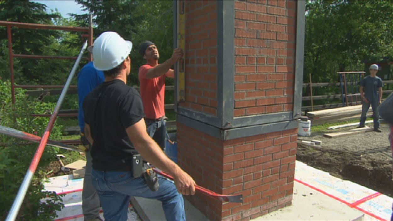 Des élèves du Centre de formation professionnelle 24-Juin construisent une cheminée.