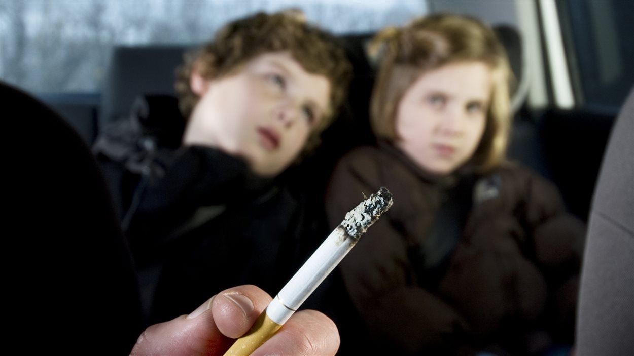 Des enfants dans une voiture avec une cigarette.