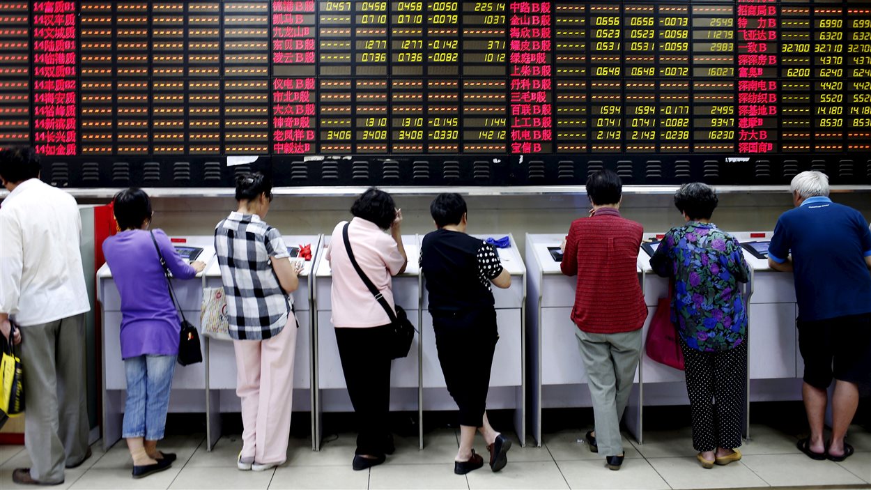 Des investisseurs devant les cours de la Bourse de Shanghai