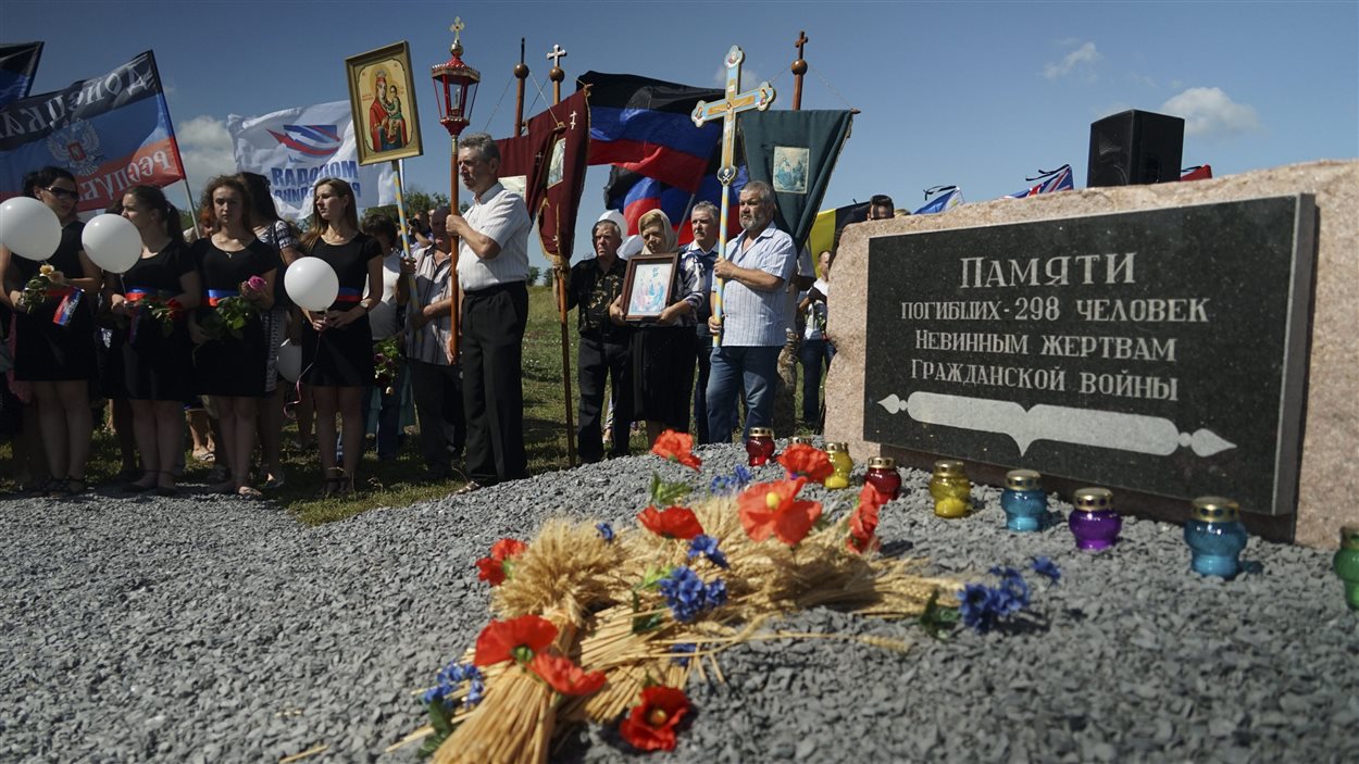 Dans l’est de l’Ukraine, des gens se tiennent sur les lieux de l’écrasement de l’appareil de la Malaysia Airlines, un après la tragédie.