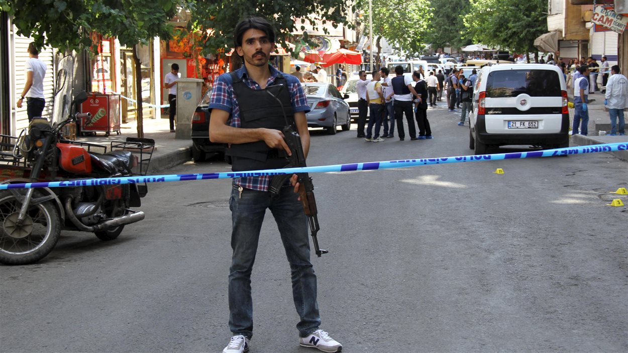 Un policier habillé en civil monte la garde après un attentat survenu près de la ville-frontière turco-syrienne. (23 juillet 2015)