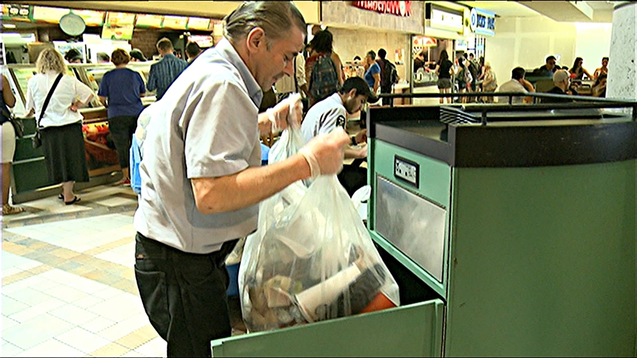 Un concierge vide les poubelles dans un centre commercial d'Ottawa (archives).