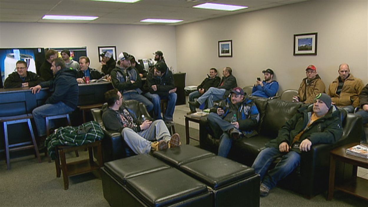Des Néo-Brunswickois qui partent travailler dans l'Ouest canadien attendent leur vol à l'ancien aéroport de Moncton.