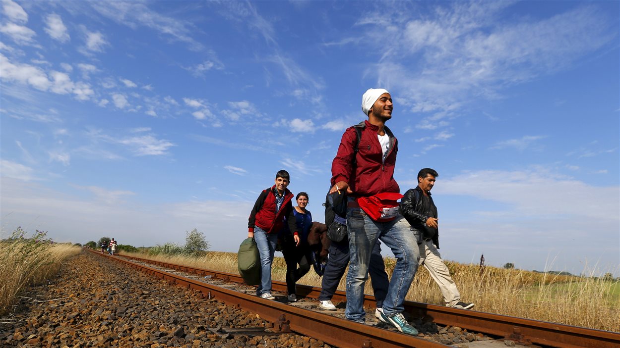 Des migrants syriens longent la voie ferrée après avoir traversé la frontière entre la Serbie et la Hongrie.