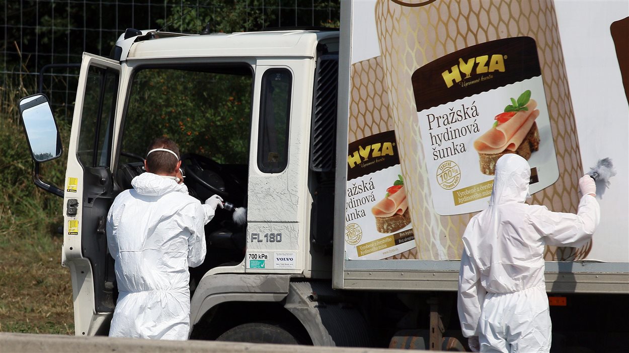 Les enquêteurs autrichiens inspectent le camion contenant les corps de dizaines de migrants, le 27 août. Le camion a été laissé au bord d'une autoroute à quelque 40 km de Vienne.