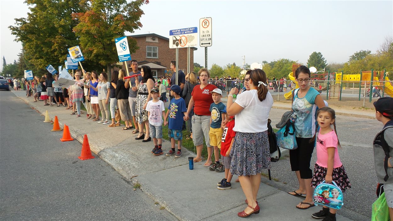 Par ce geste symbolique, les manifestants veulent créer un rempart afin que l'école soit épargnée des effets négatifs qu'auront les réductions budgétaires imposées en éducation.