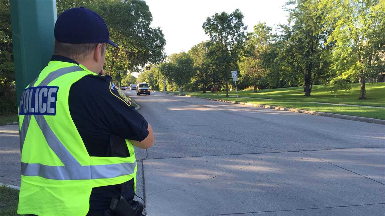 Un agent du Service de police de Winnipeg surveille les automobilites pour des excès de vitesse près de l'école Dalhousie à Winnipeg.