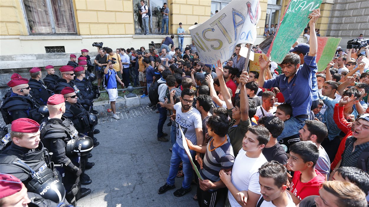 Des migrants coincés à Budapest affrontent des policiens juste à l'extérieur de la gare.