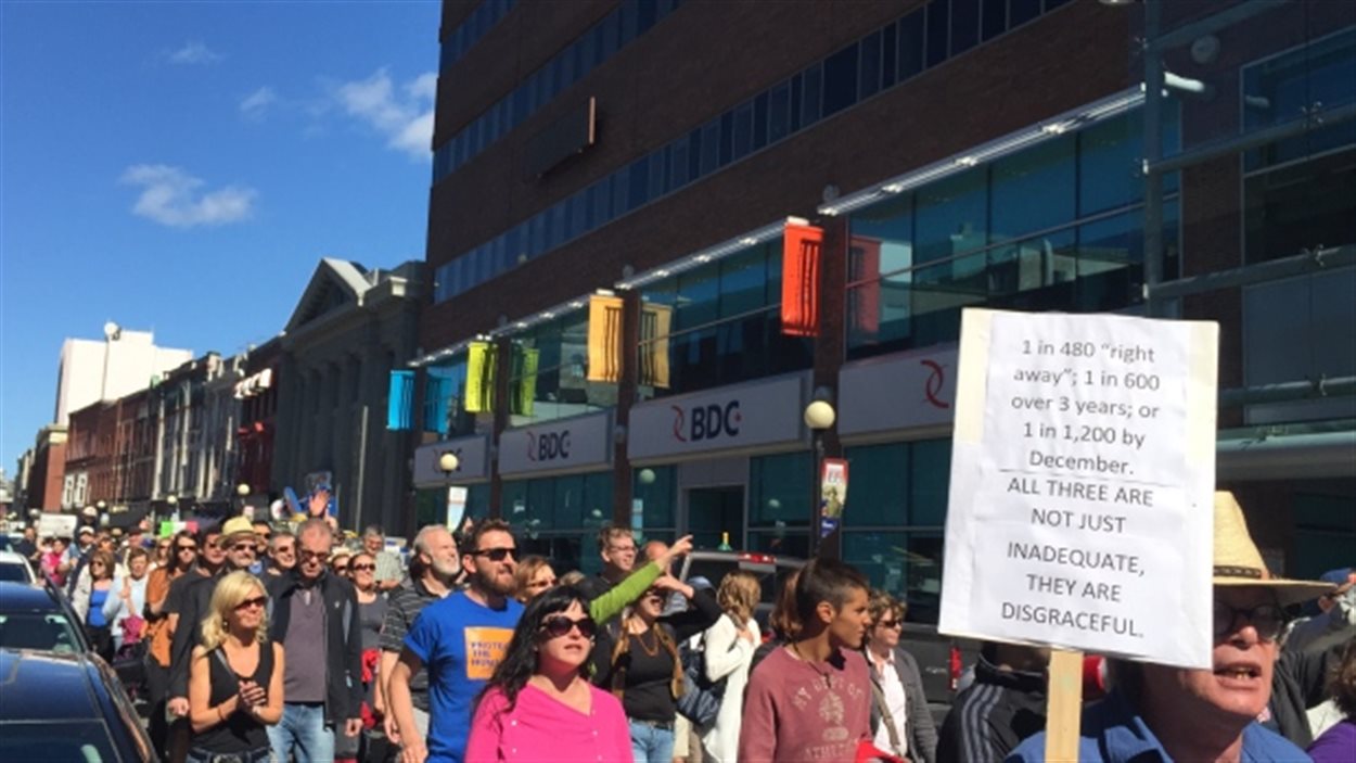 Des manifestants à Saint-Jean demandent au gouvernement canadien d'ouvrir ses frontières aux réfugiés.