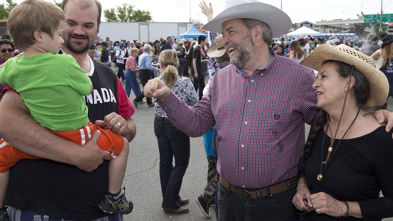 Le chef Thomas Mulcair à la rencontre de familles lors du Stampede de Calgary, le 4 juillet dernier. Sur la photo : le petit Elijah et son père, Rod Day. 