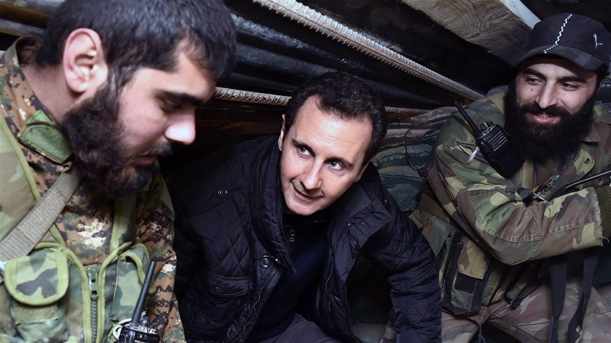 Cette photo de l'agence officielle syrienne SANA montre le président syrien Bachar-Al-Assad en discussion avec des militaires.