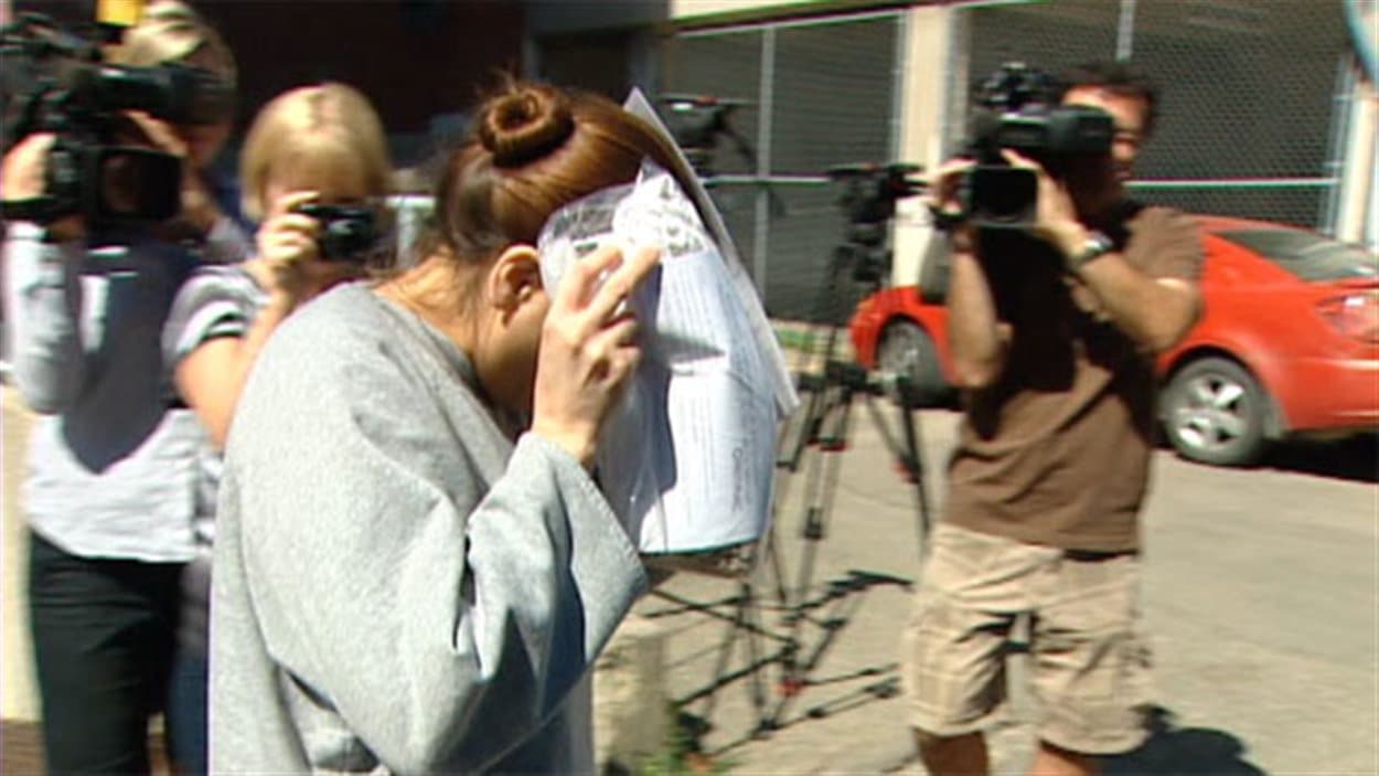 Tammy Goforth, accusée de meurtre non prémédité contre une fillette de 4 ans, se couvre le visage à la sortie du palais de justice de Regina en 2013.