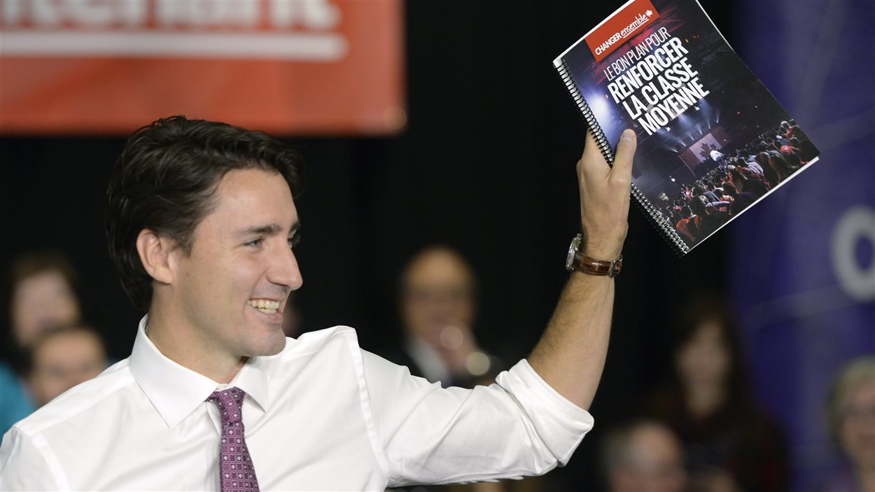 Justin Trudeau brandissant la plateforme électorale du Parti libéral.