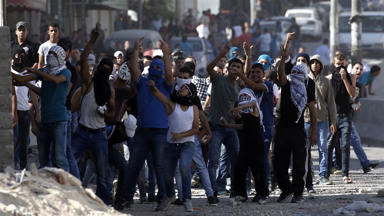Des Palestiniens lancent des pierres à des soldats israéliens au point de passage de Qalandia, qui sépare Jérusalem de la Cisjordanie.