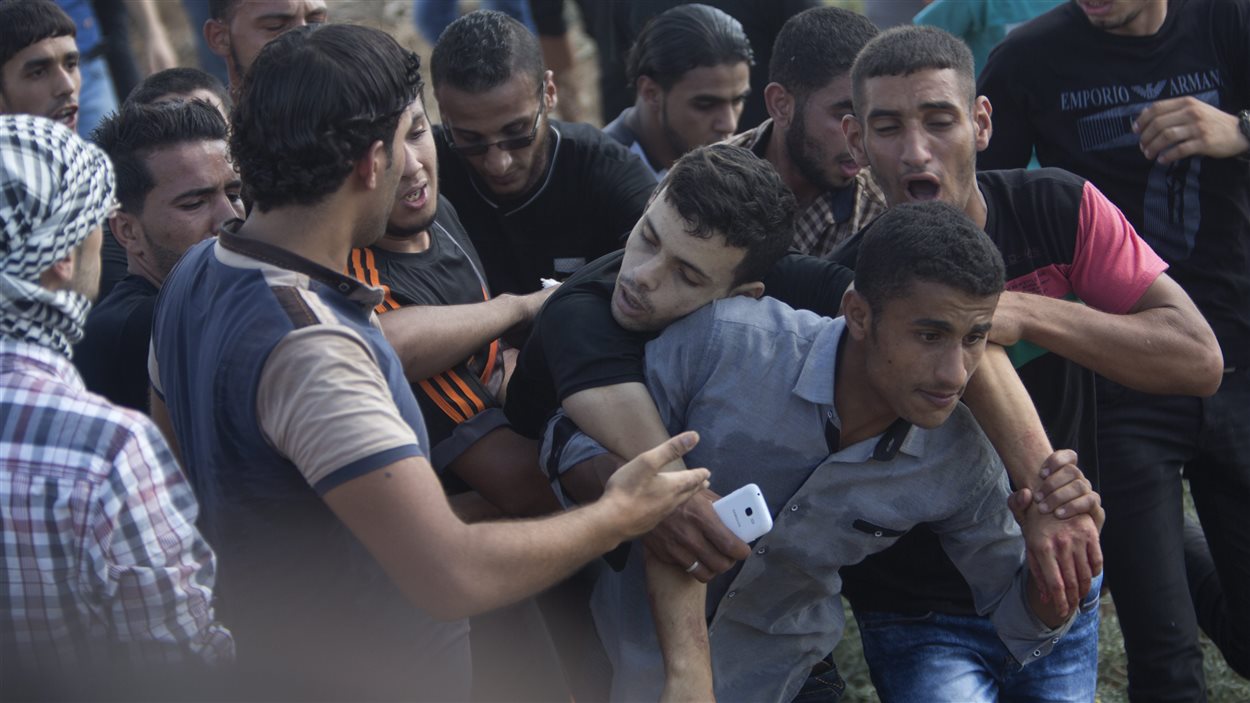 Des Palestiniens transportent un blessé à la suite de heurts avec des soldats israéliens à la frontière entre la bande de Gaza et Israël.