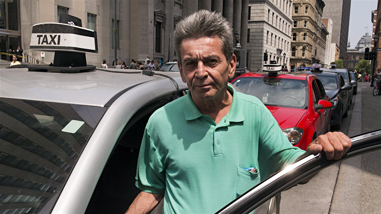 Ce chauffeur de taxi montréalais a presque 20 ans d'expérience. Il attend un client dans le Vieux-Montréal.