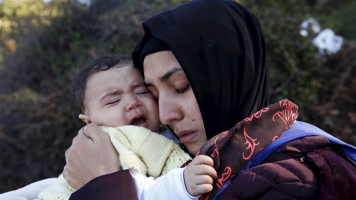 Une réfugiée syrienne enlace son bébé qui pleure, après être arrivée sur l'île de Lesbos à bord d'un radeau.