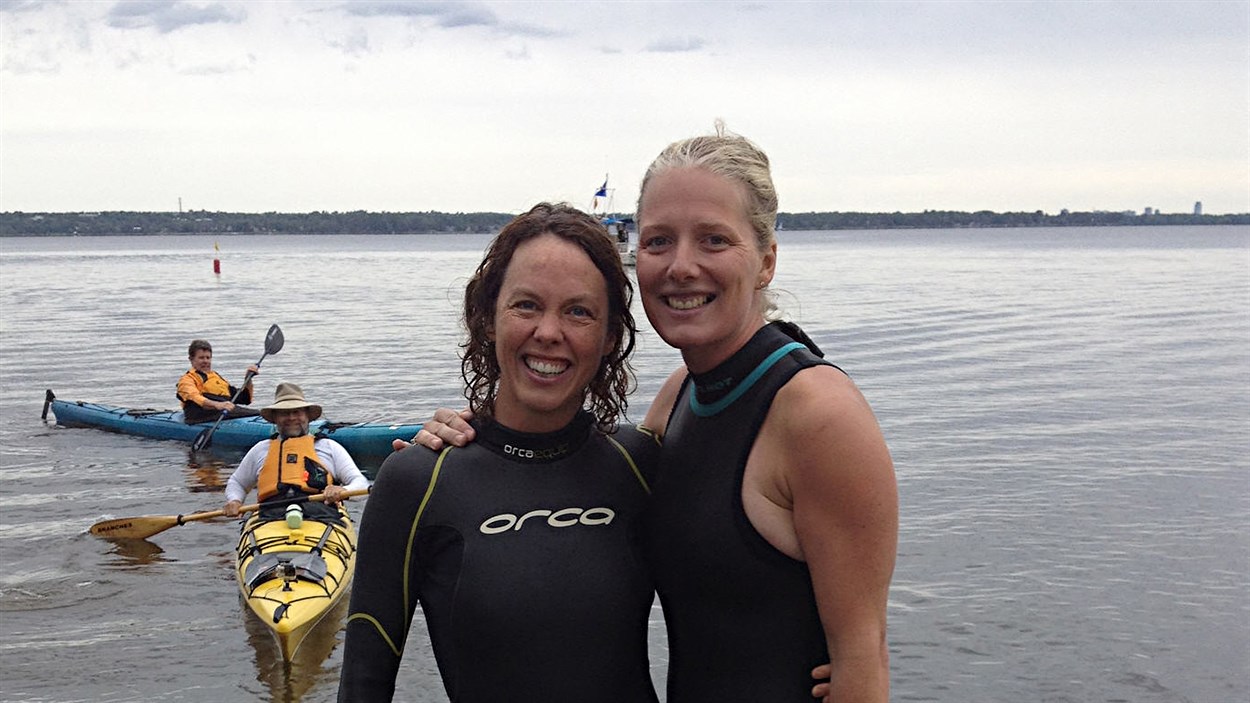 Catherine McKenna (à gauche) en compagnie d'une responsable de l'organisme Sentinelle Outaouais (à droite), lors d'une compétition de natation organisée dans la rivière des Outaouais.