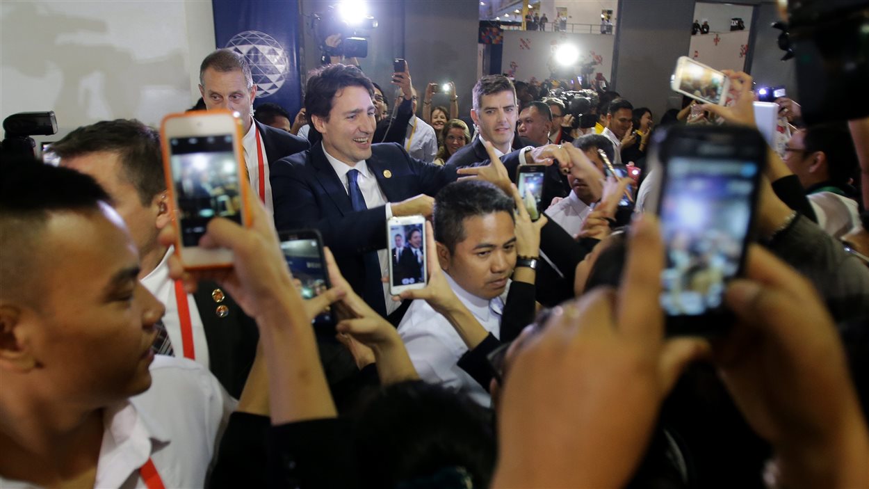 Le premier ministre Justin Trudeau entouré par des admirateurs au moment où il quitte le centre international de presse à Manille.