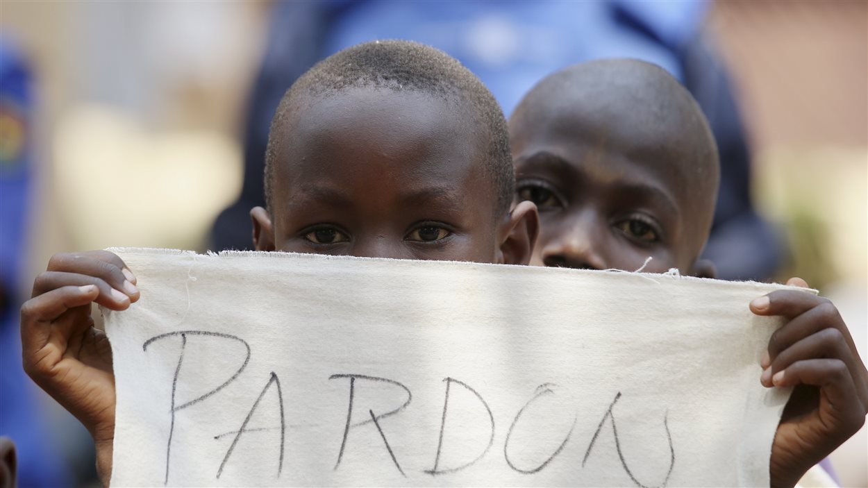 Un enfant tient un bout de tissus sur lequel se lit « Pardon » pour la visite du pape François dans le camp de réfugiés de Saint Sauveur, dans la capitale. (29 novembre 2015)