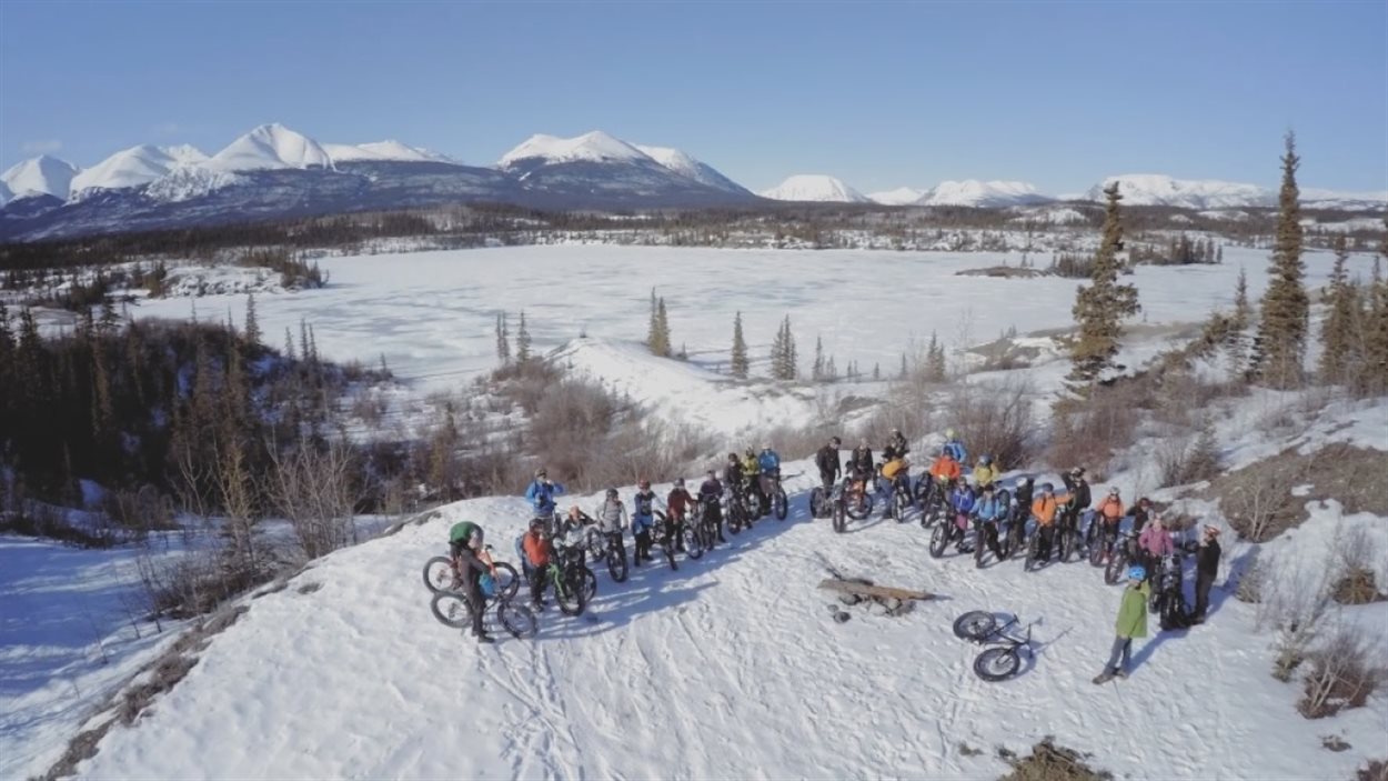 Un groupe de cyclistes en hiver près d'un lac