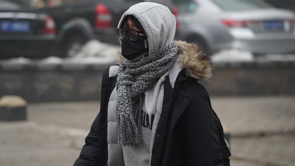 Un Pékinois masqué lutte contre la pollution.