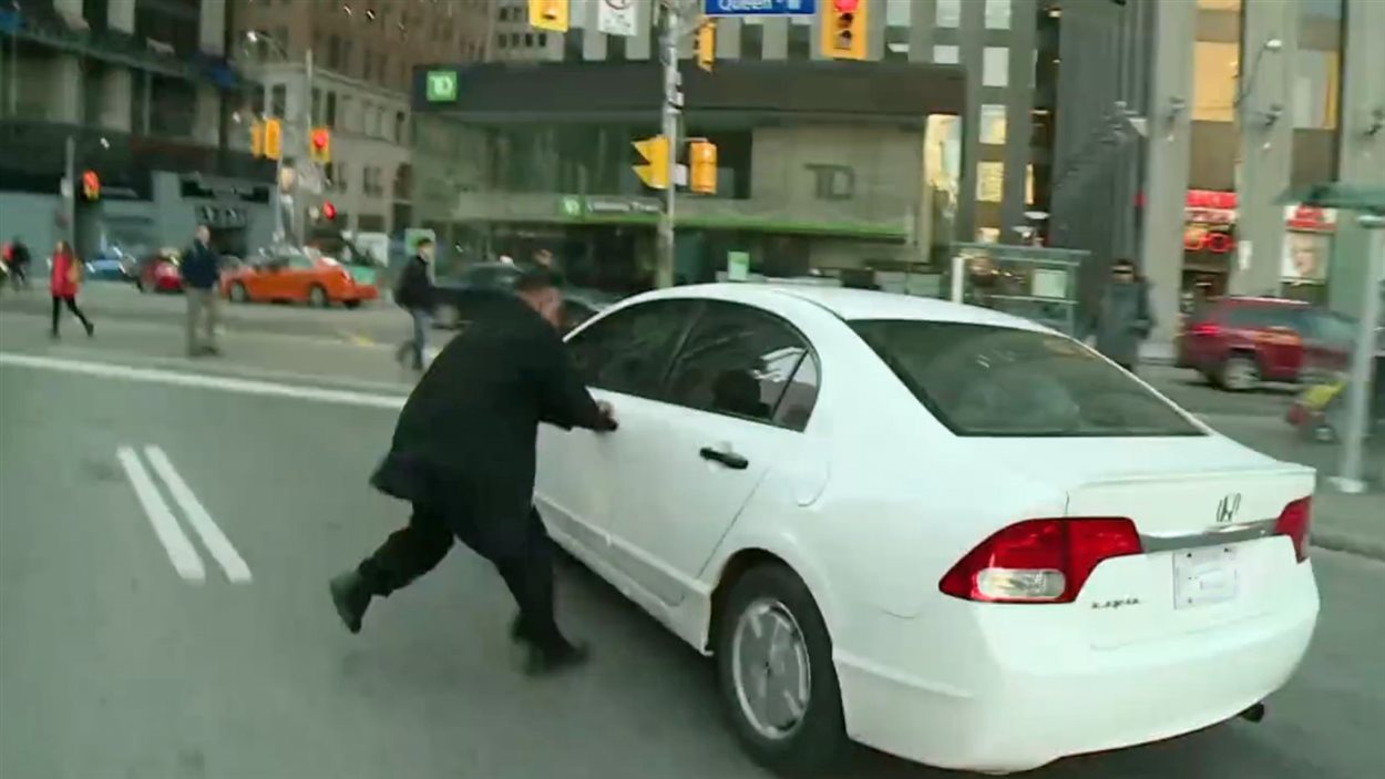 Le chauffeur de taxi agrippe la portière du véhicule du conducteur d'UberX.
