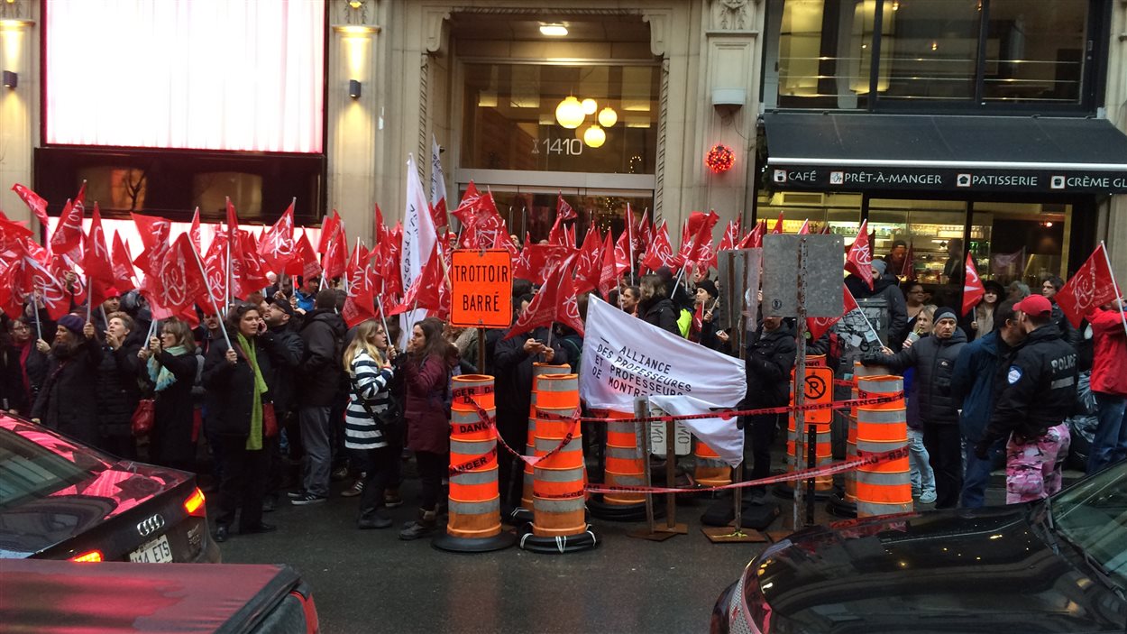 Des syndiqués de la FAE manifestent devant les locaux du Conseil du Trésor à Montréal.