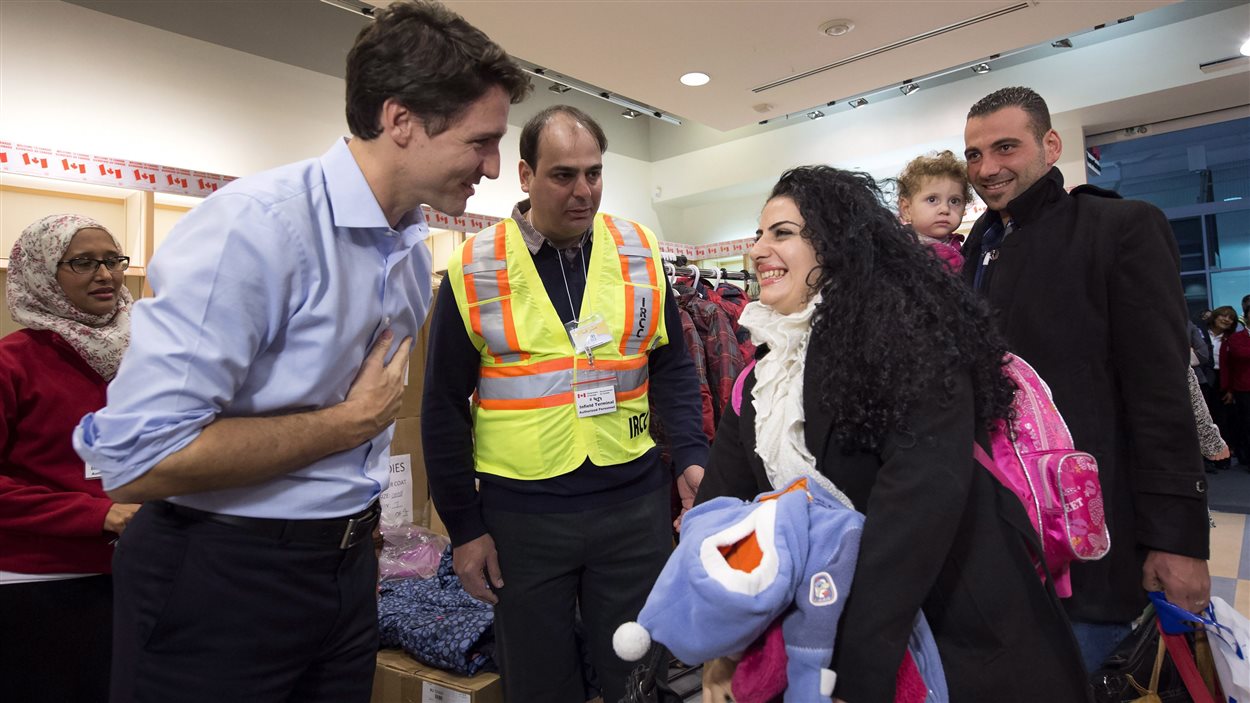 Le premier ministre Justin Trudeau accueille les premiers réfugiés syriens arrivés dans un vol nolisé à l'aéroport Pearson de Toronto.