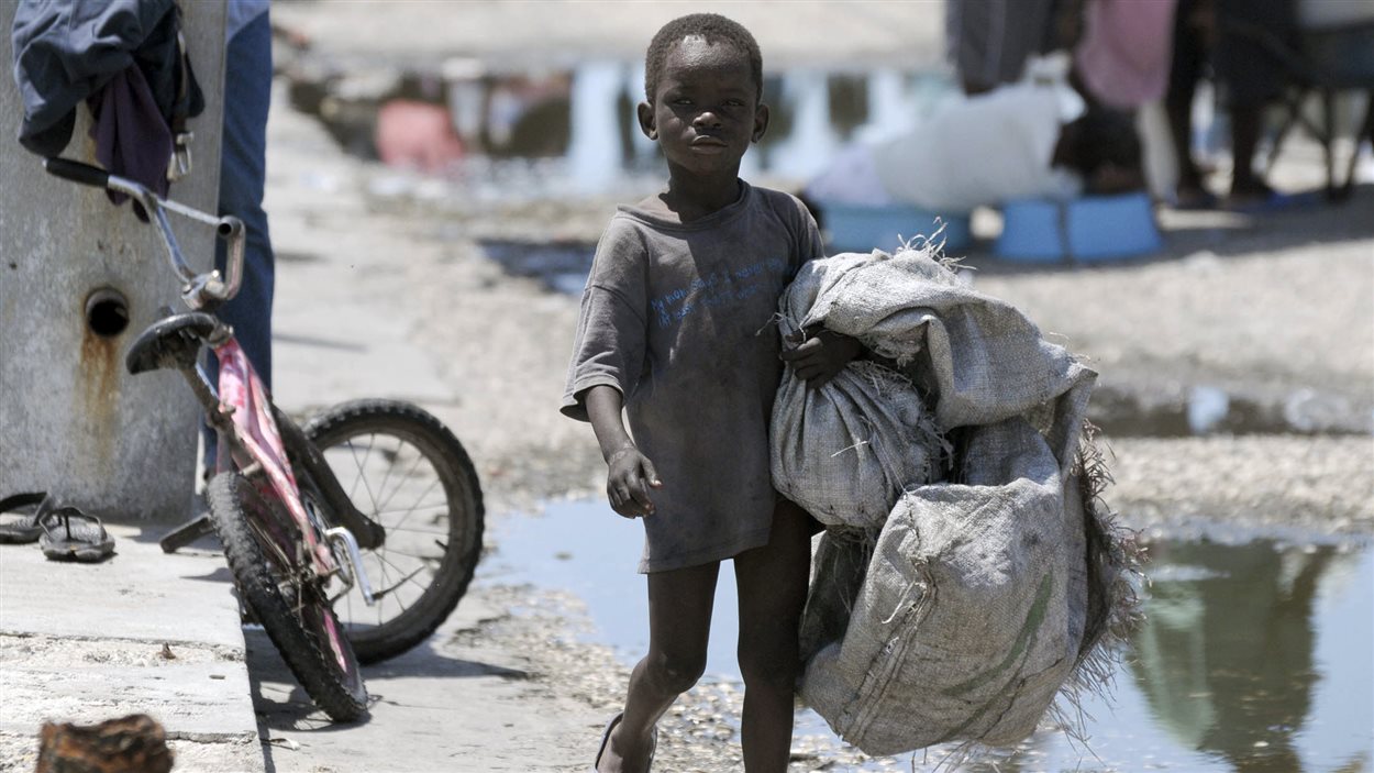 Un enfant haïtien transporte des sacs à Port-au-Prince