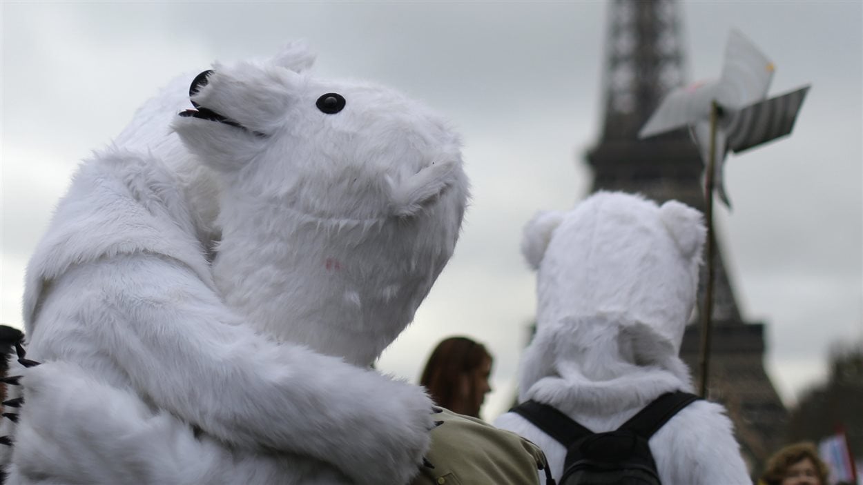 Des militants écologistes manifestent devant la tour Eiffel à Paris, le 12 décembre.